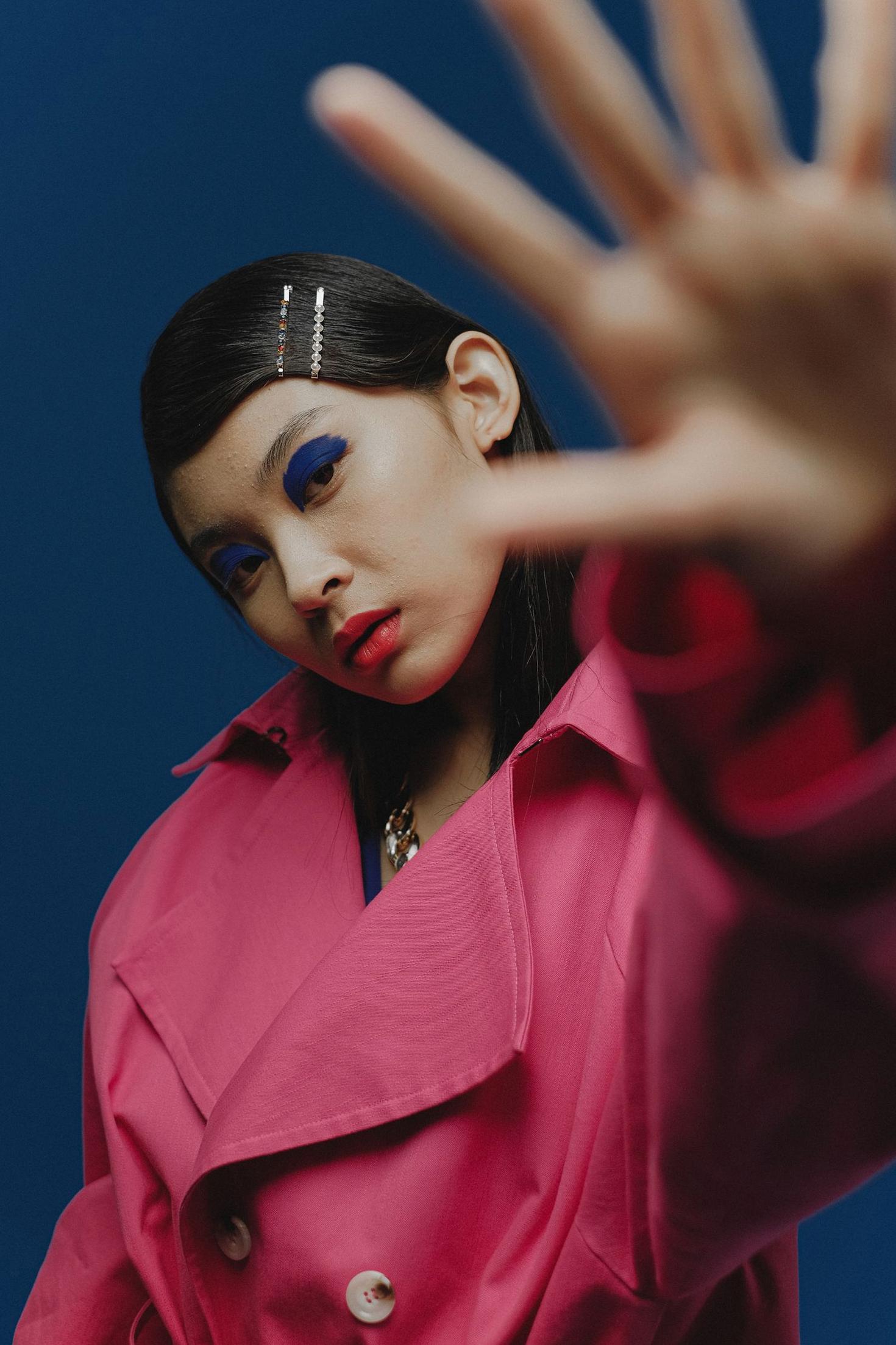 Primary campaign portrait: Model in structured pink outerwear